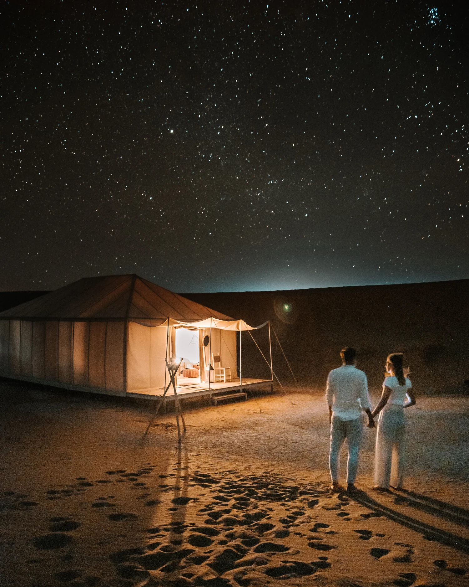 Couple stargazing in the Sahara
